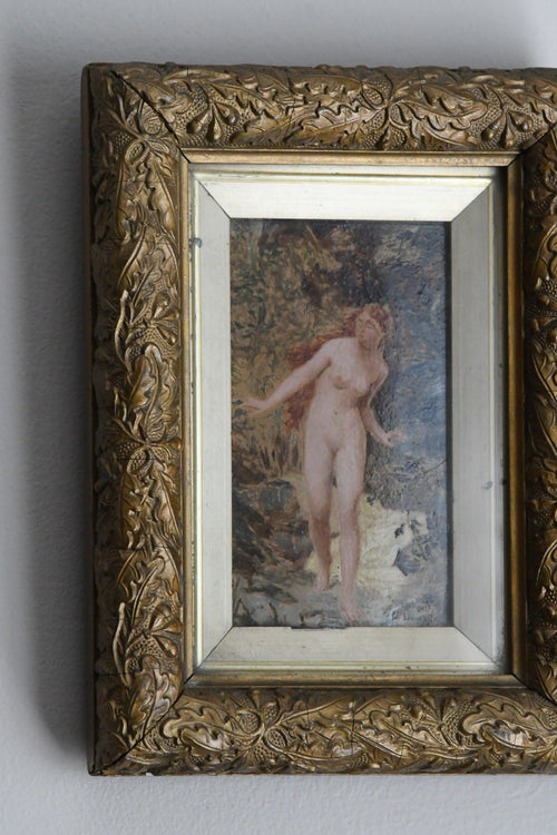 Decorative gold frame with a painting of a nude figure with a woodlands background